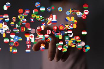 Abstract image of a hand interacting with numerous flags representing global connectivity.