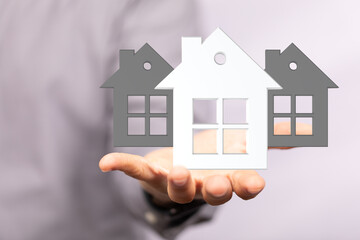 Image of a real estate agent presenting house models, symbolizing home buying or selling.