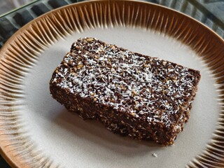 Homemade dessert Raw Chocolate Coconut slice on a Ceramic Plate