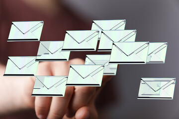 A person interacts with a digital display showing numerous email messages, symbolizing email...
