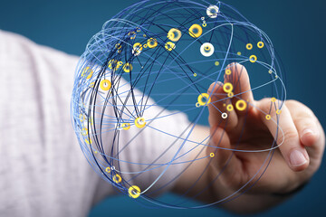 Abstract image of a hand interacting with a digital network sphere, representing global...