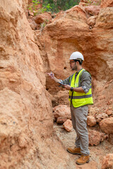 A geologist is examining the mineral content of soil and recording it on paper