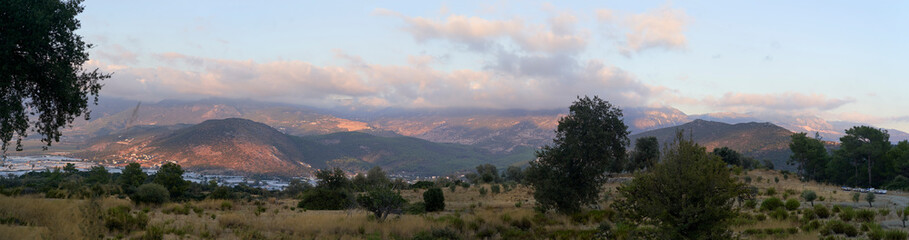 Mediterranean mountain range landscape with trees and cloudy sky at sunset on the Lycian Way in Turkey