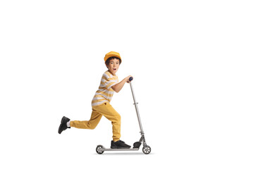 Full length profile shot of an excited kid riding a push scooter