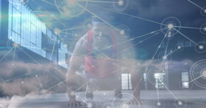 Image of network of connections over clouds and fit african american man doing push ups