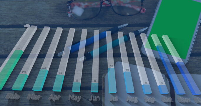 Image of graph processing data over notebook, pens and smartphone on desk