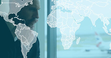 Image of world map over caucasian businessman at airport