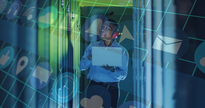 Image of data processing over male african american server room worker using headphones