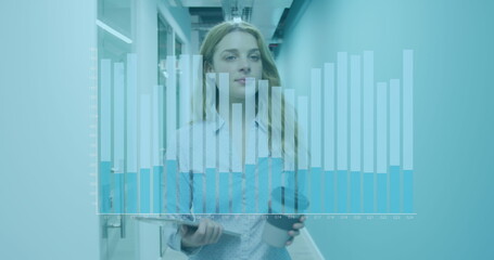 Image of financial graphs over caucasian woman with coffee walking in office