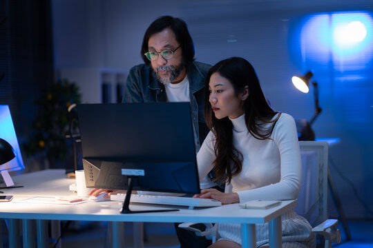 group of Happy young asian business people chatting happily after a night of overtime work in the office.Supervisor chats with employees after working together planning success strategy enjoy teamwork