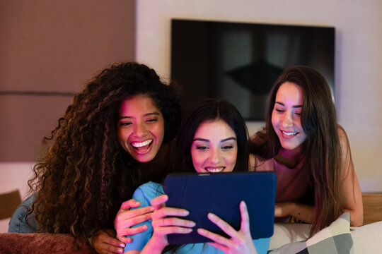 Friends enjoying digital tablet together indoors
