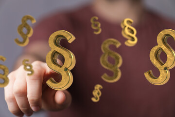 Golden paragraph symbols floating around a hand, ideal for legal, law, and justice concepts.
