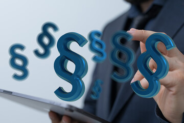 Abstract image of paragraph symbols hovering over a tablet, representing digital law or legal tech.