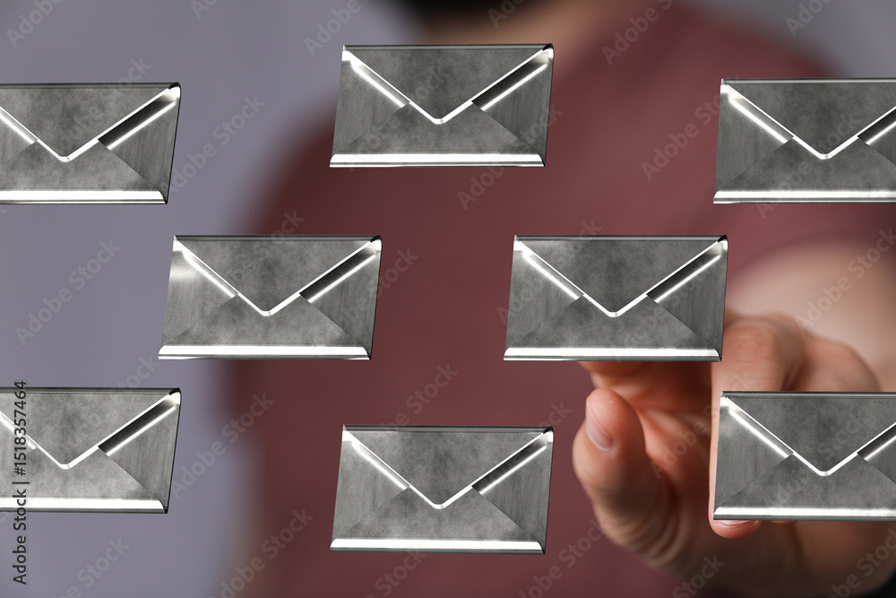 Wall mural abstract image of a man interacting with floating metallic email icons, representing digital communi