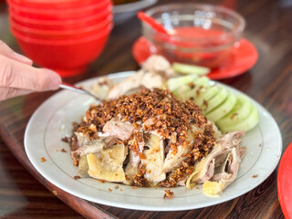 Pek Cam Kee, a traditional Hokkien-style poached chicken dish, served with fragrant garlic oil and accompanied by dipping sauces, captured in Puncak, Cipanas, West Java, Indonesia.

