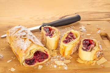 Strudel with cherries on a wooden table, close-up.