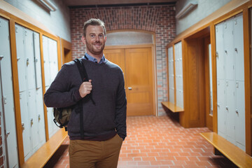 Metal lockers lining long corridor with terracotta floor tiles and brick arch doorway, copy space