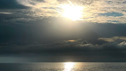 A serene seascape under a dramatic, cloud-filled sky.