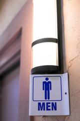 A men's bathroom with the sign in focus.