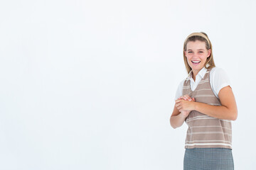 Smiling woman clasping hands at chest level in studio against white backdrop, copy space