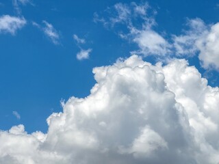 Fototapeta premium Blue sky with clouds background, sunny day. White and grey fluffy cloudscape