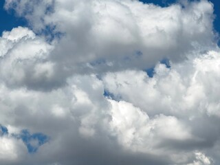 Obraz premium Blue sky with clouds background, sunny day. White and grey fluffy cloudscape