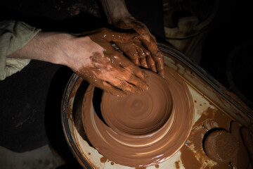 A person is making a pottery piece with their hands