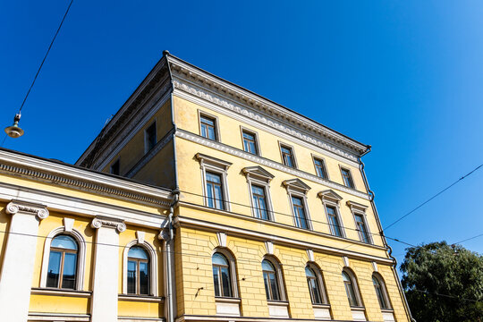 Bright yellow building in Helsinki, Finland, viewed from a low angle against a clear blue sky. - Powered by Adobe