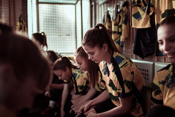 Girls soccer team getting ready in locker room before game