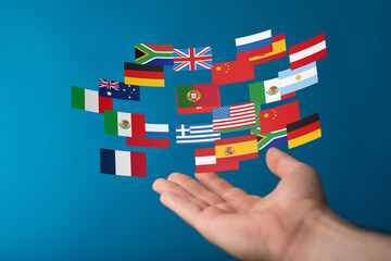 Diverse flags floating above an open hand, symbolizing global reach and international collaboration.