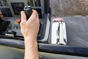 Control panel of construction hoist operated by male hands, top view from crane basket. Industrial...