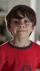 Obraz premium Young boy smiling warmly, looking directly at the camera, cheerful and joyful expression, capturing an innocent and happy moment in a home setting
