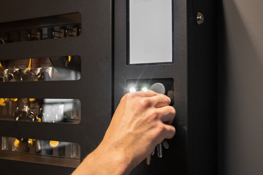 Person using RFID key fob for secure access control system with key management. Ideal for security, smart office, or technology themes.