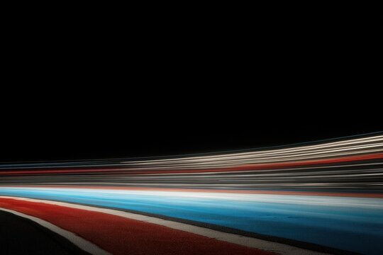 dynamic streaks of red, white, and blue light trails against a black backdrop