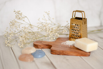 Aromatherapy wax melt block with grated flakes on a wooden board, styled with candle and flowers....