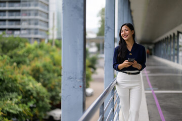 Professional businesswoman working on smartphone, walking through contemporary corporate workspace with confident smile