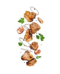 Levitation of fried meat with garlic and herbs on a white background