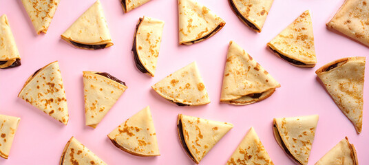 Chocolate-filled crepes neatly arranged in a regular pattern on a soft pink background, creating a visually appealing and deliciously themed layout ideal for sweet treat promotions