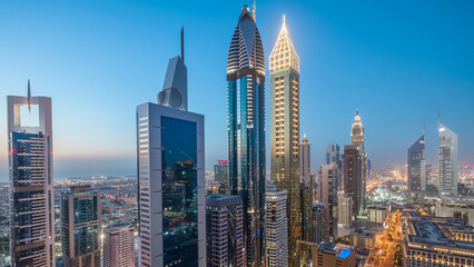 Obraz premium Skyline view of the buildings of Sheikh Zayed Road and DIFC day to night timelapse in Dubai, UAE.