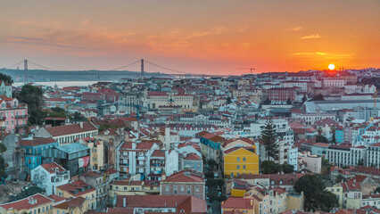 Lisbon at sunset aerial panoramic view of city centre with red roofs at autumn evening timelapse, Portugal