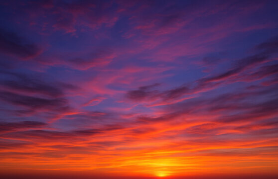 Fiery sunset sky with deep orange, purple and indigo clouds