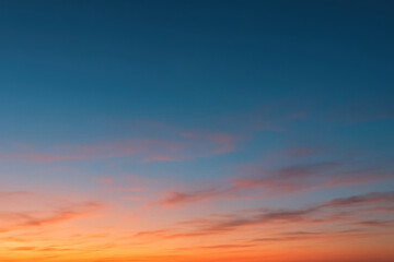 Fototapeta premium Peaceful sunset with orange and blue gradient colors and scattered clouds