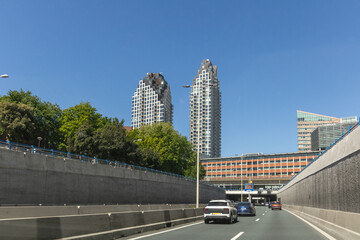 Utrechtsebaan A12 highway in The Hague, Netherlands, seen from a tunnel road with traffic on a sunny day, showcasing urban development and design.