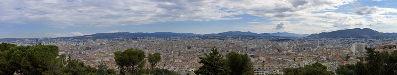 Fototapeta premium Panoramic shot of Marseilles in France taken from above over the roofs, harbor and city center with churches