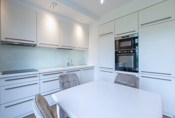 Modern Bright Home Kitchen Interior With White Cabinets and Cozy Dining Area