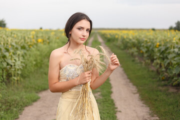 woman walking in golden dried grass field.