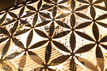 An ornate metal lamp adorned with floral sharp cutwork background pattern 