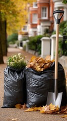 Black garbage bags filled with dead plants sit on the driveway in a rainy English garden surrounded by falling autumn leaves