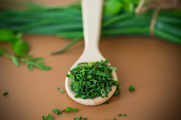 Dried and fresh green onions on brown background from above