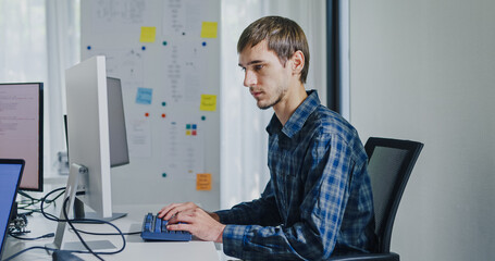 Young adult male freelance developer typing write prompt AI bot app program nomad terminal with coding at office. Artificial intelligence dashboard, robotics, user interface, machine learning concept.